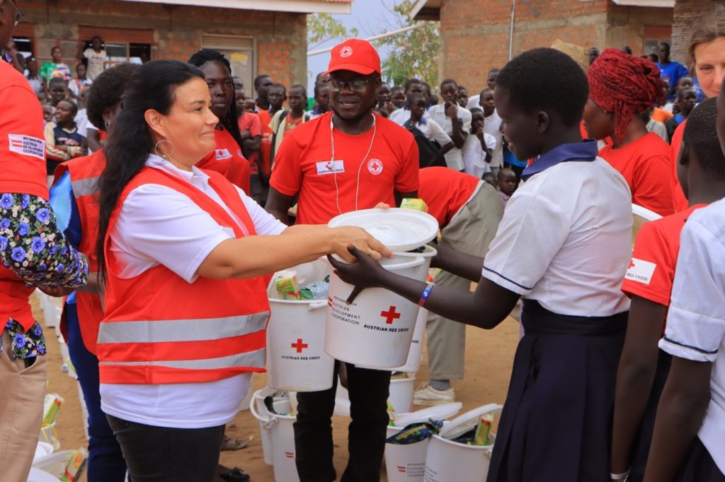 Head of Office - Austria Red Cross in Uganda, Angelika Forsstroem distributes Menstrual Hygiene Management (MHM) Kits to girls in Yangani Primary School, Yangani village, zone 5, Bidibidi refugee settlement. 