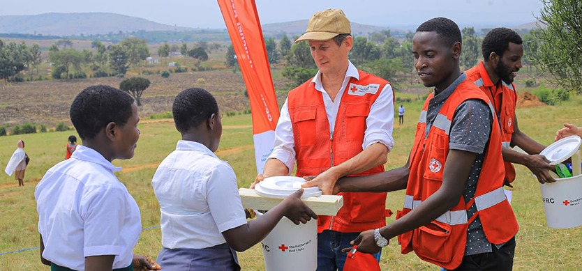 Andrew Smith Head of Office Netherlands Red Cross supporting during the distribution of the menstrual hygiene kits in the Nakivale refugee settlement.