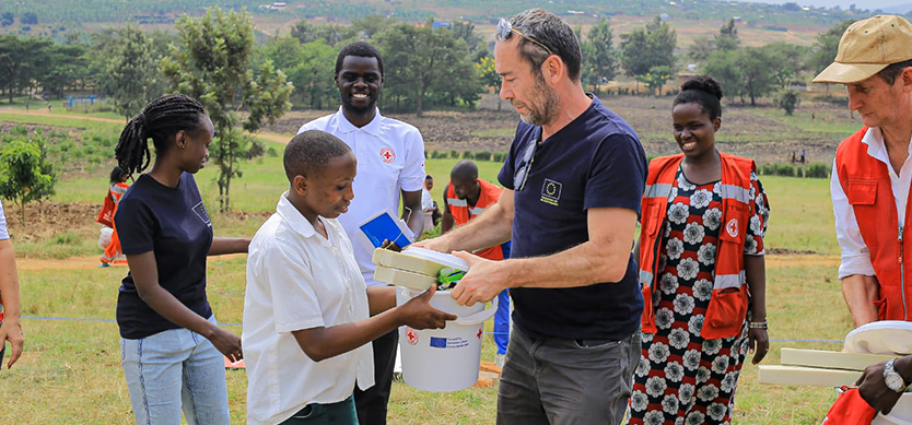 Bruno Rotival the Head of the Office of European Civil Protection and Humanitarian Aid Operations (EU ECHO) in Uganda supports the distribution of menstrual hygiene kits in the Nakivale Refugee Settlement.