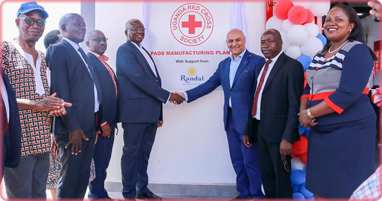 Robert Kwesiga, the secretary general of Uganda Red Cross Society, and Dr. Nik Kotecha, the founder of Randal Charitable Foundation, shake hands after opening the pads production facility in Namakwa, Mukono district.